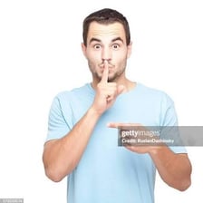 Person holding a finger to their lips to request silence