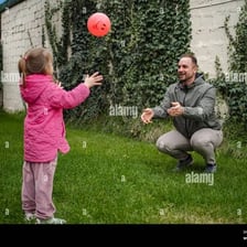 People playing catch in a grassy yard.