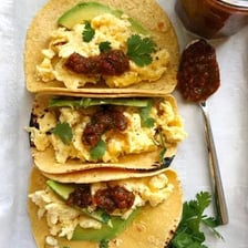 A bowl of salsa served alongside tacos.
