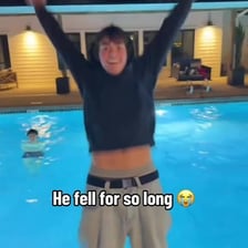 A person slipping into a swimming pool in a comic mishap.