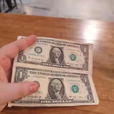 One-dollar bills placed in a tip jar