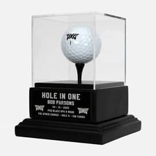 A golf ball resting in a hole after a hole-in-one shot