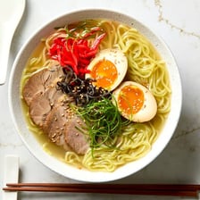 A bowl of tonkotsu ramen with noodles and toppings