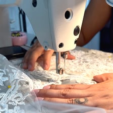 A tailor measuring a dress for a clothing alteration.