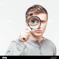 A person examining something through a magnifying glass