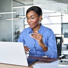 An assistant helping someone at a desk.