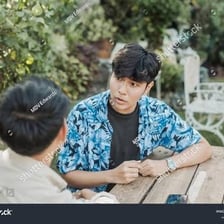 A person gives a skeptical reaction while listening to someone.