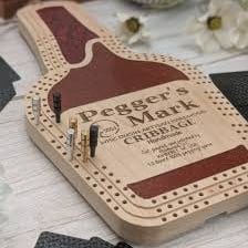 A small peg marking a position on a wooden cribbage board.