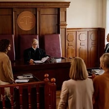 A person speaking earnestly during a court hearing.