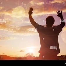 A person with raised hands during a moment of praise.