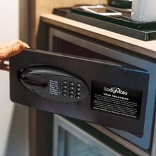 A small electronic safe mounted inside a hotel room closet.
