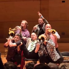 A brass band performing with trumpets and trombones