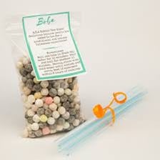 A cup of boba tea with tapioca pearls and a wide straw.