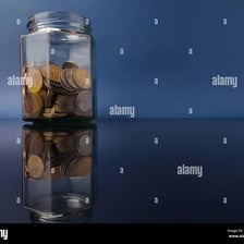 Coins gathered together in a glass jar.