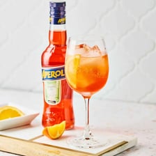 An orange Aperol Spritz cocktail in a wine glass