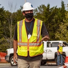 A road worker wearing a high-visibility reflective vest.