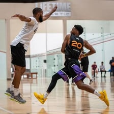 A basketball player taking steps toward the basket for a layup.