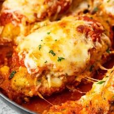 A serving of chicken Parmesan topped with melted cheese and tomato sauce.