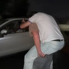 A driver opening a car door and inviting someone to get in.