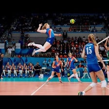 A volleyball player jumping to hit the ball sharply over the net.