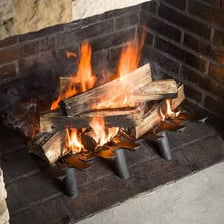 An iron grate holding logs inside a traditional fireplace