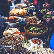 A table filled with varied dishes at a potluck meal.