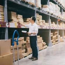 A warehouse worker checking stock and ordering replacement inventory
