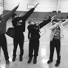 A person performing the dab dance move with one arm extended and the head lowered toward the other arm.