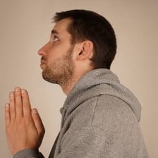 A person making an earnest request with clasped hands