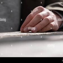 A hand gently patting a surface.