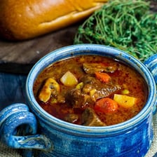A bowl of thick stew with vegetables and meat