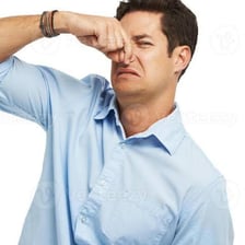 A person covering their nose after encountering an unpleasant smell.