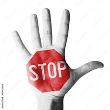 A person holding up a hand to signal stop.