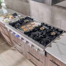 A kitchen stove with burners on its range top