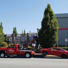 One vehicle pulling another vehicle with a tow line.