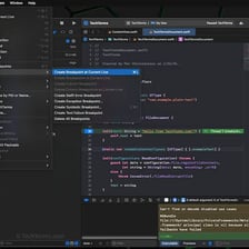 A programmer works at a computer while reviewing code.