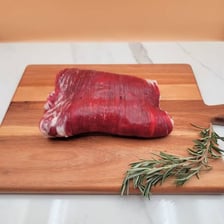 A trimmed beef loin cut displayed at a butcher counter.