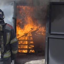 Fire investigators examining the remains of a burned building.