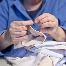 A person stitching fabric with a needle and thread.