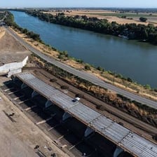 A raised levee runs along the bank of a river.