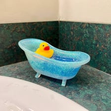 Yellow rubber ducks floating in a bathtub.