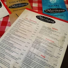 An Italian menu using the preposition “alla” in a dish name.