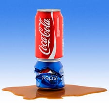 Coca-Cola and Pepsi cans representing cola soft drinks