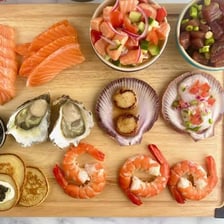 A platter containing scallops, shrimp, and other seafood