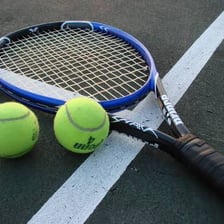 A tennis racket and ball on a tennis court