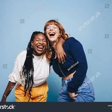 Two female friends smiling and talking together.