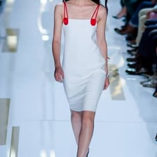 A fashion model walking on a runway.