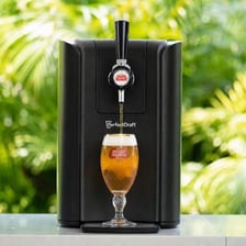 A beer tap positioned over a glass and ready to pour.