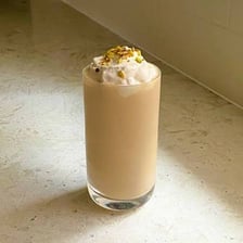 A glass of mango lassi, a creamy mango-and-yogurt drink.