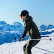A skier gliding down a snow-covered mountain.